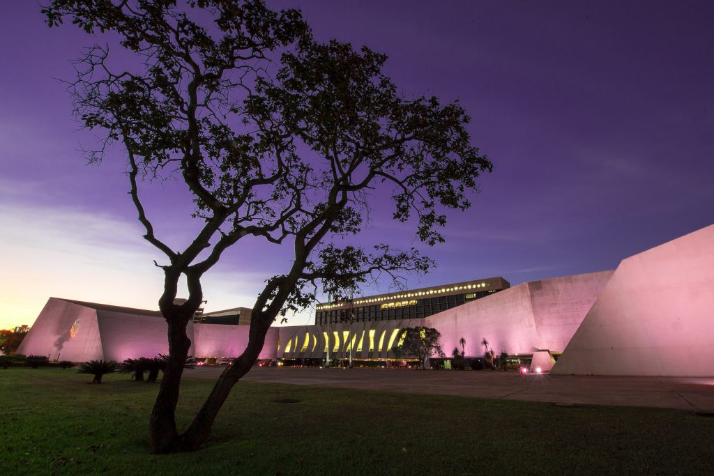 Fachada do STJ com visão das bandeiras e iluminação roxa. Créditos: Gustavo Lima/STJ